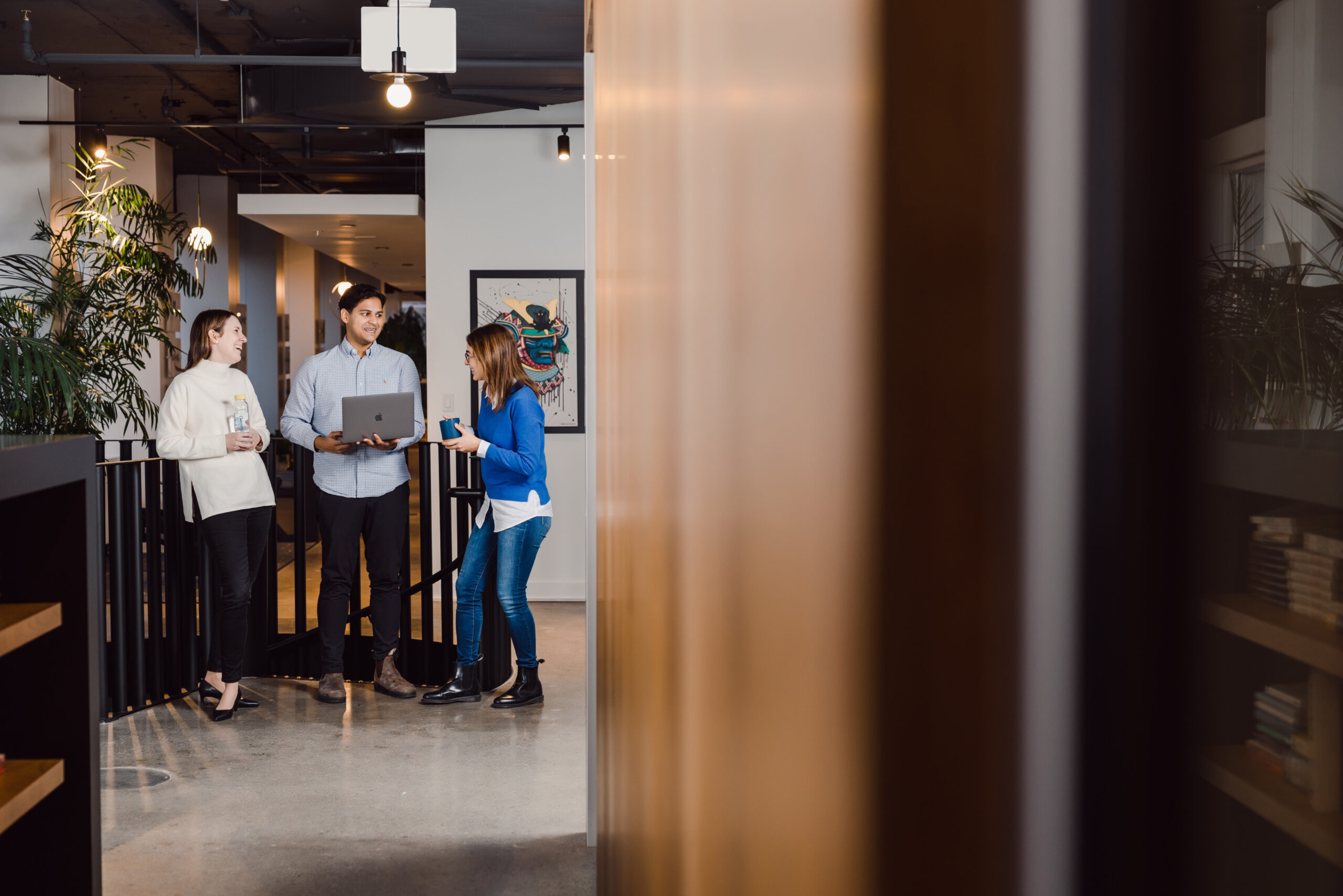 Coworkers leaning on the stair's railing while chatting