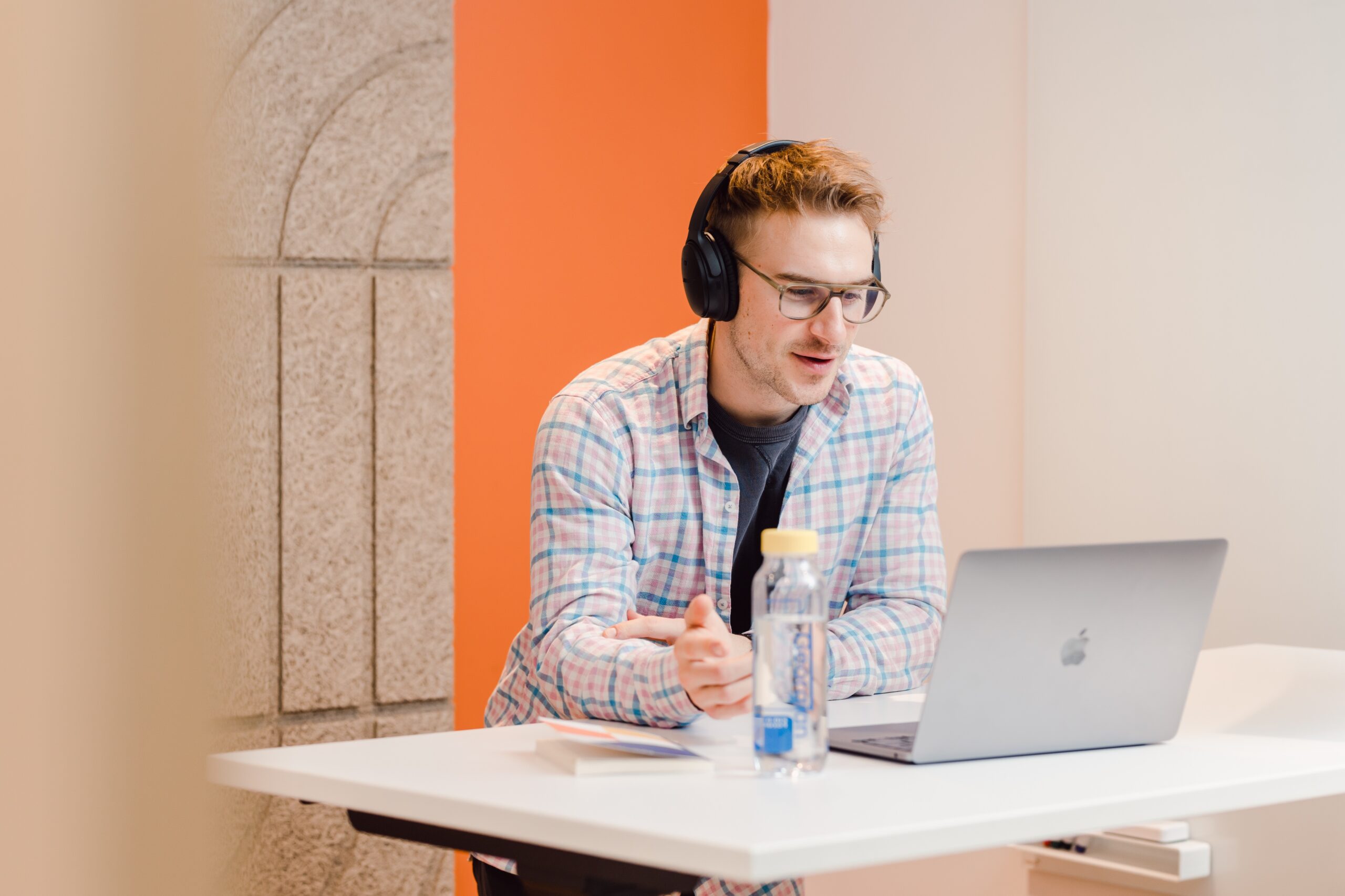 A person is in front of their laptop during a meeting at their office