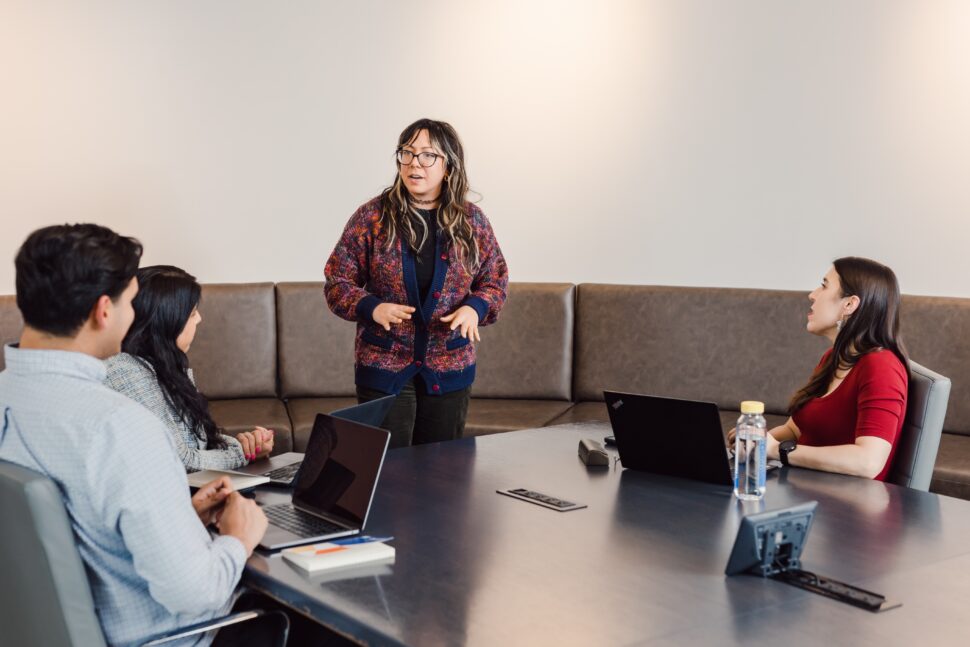 An employee is leading and presenting to the team during a meeting